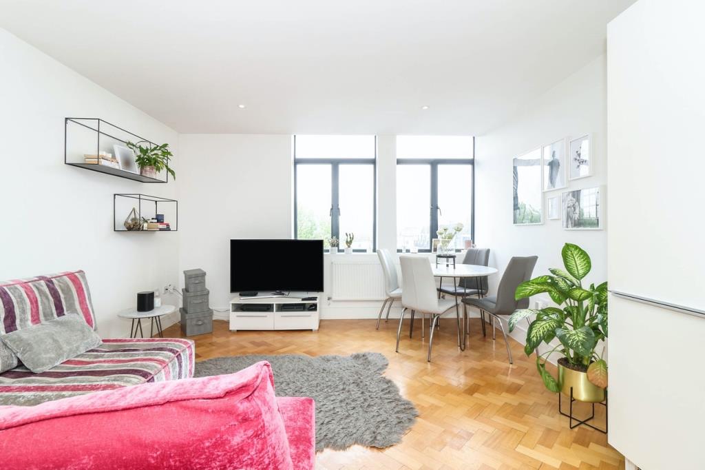 Lot: 32 - TWO-BEDROOM CITY CENTRE APARTMENT - Living room and fitted kitchen area with parquet wooden flooring